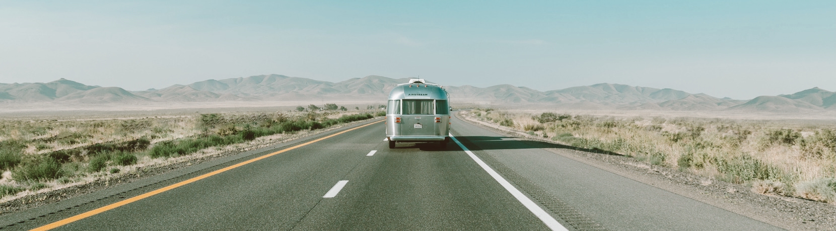 Airstream camper driving down the road